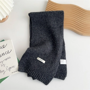 Macro shot of 100% wool label on dark grey knit scarf with classic ribbed texture details