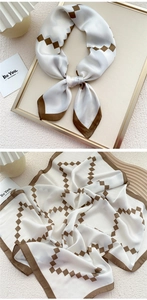 Detailed view of square silk scarf with brown geometric diamond pattern and rolled edges