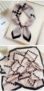 Detail of champagne gold silk scarf with geometric black patterns and satin texture