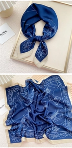Detail view showing intricate white floral architecture prints on a navy blue silk scarf