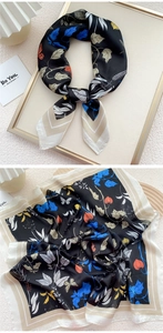 Detail of floral printed satin scarf featuring butterfly patterns and silk texture
