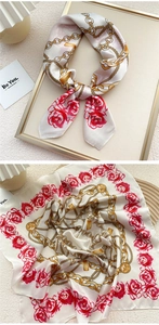 Detail of a vintage square silk scarf with golden chains and pink rose floral patterns