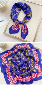 Close-up of royal blue silk scarf with golden chain patterns and red floral motifs