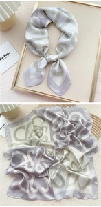 Close-up of elegant lavender and beige silk scarf with abstract geometric ring patterns