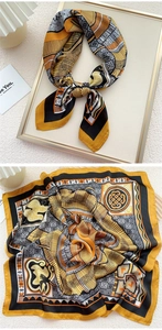 Detail of a mustard yellow and black geometric patterned silk scarf with premium textures