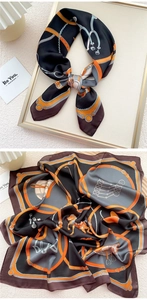 Detailed equestrian belt and chain pattern print on a luxury satin scarf with orange accents