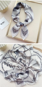 Detail of satin square scarf featuring elegant equestrian horse and strap patterns