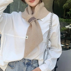 Close-up of khaki knitted scarf with contrast brown loop buckle and soft texture