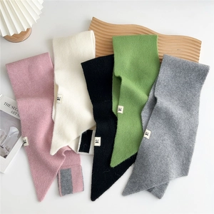 Close-up of soft knitted scarves in five colors with stylish woven texture and brand labels