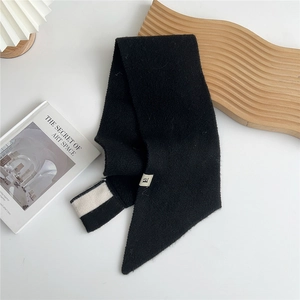 Detail of soft black knit scarf showing fine texture and stylish stripe accent