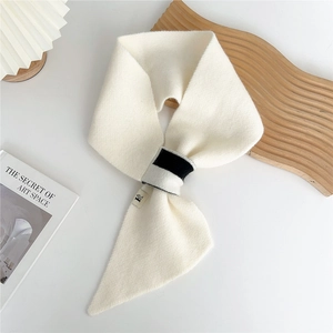 Detail of cream knit scarf featuring a contrasting black-grey loop and soft texture