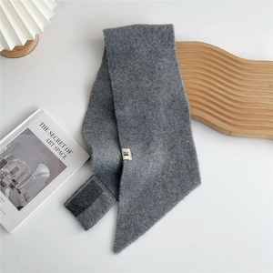 Detail of dark grey knitted scarf showing soft texture and Velcro fastener design
