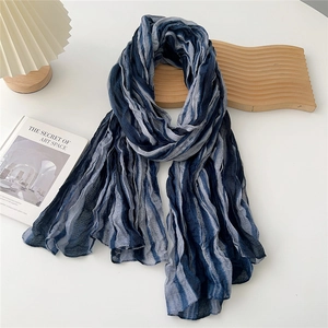 Detailed view of the striped pleated fabric texture on a gradient blue fashion scarf