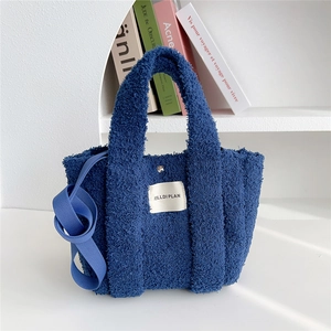 Detail of blue plush teddy fleece handbag with magnetic clasp and shoulder strap