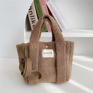 Detail of brown plush crossbody tote bag featuring soft fleece texture and round handles
