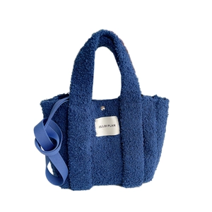 Blue fuzzy fleece tote bag with MILLDI PLAN label and adjustable shoulder strap