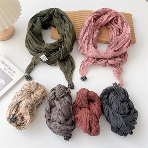 Mise à plat d'écharpes plissées en coton et lin en six couleurs avec pompons décoratifs