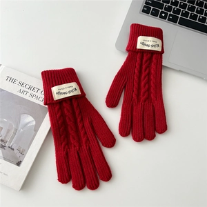 Detail of red cable knit gloves with touch screen design and warm thermal fabric
