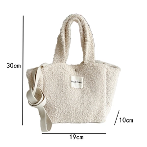 Detail of cream fleece crossbody bag with brand label and adjustable shoulder strap