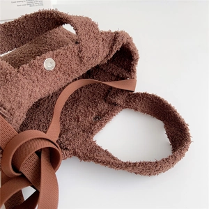 Detailed macro of brown teddy fleece tote bag featuring secure magnetic metal closure