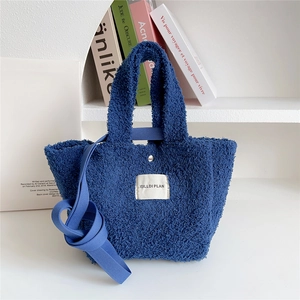 Close-up of blue teddy plush handbag showing fuzzy texture and metal magnetic closure