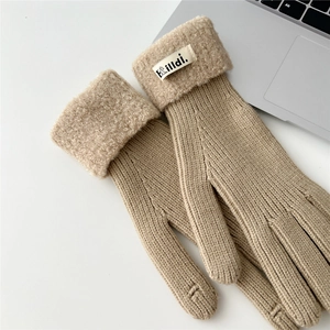 Detail of beige knitted winter glove with plush faux fur cuff and hilldi. brand label