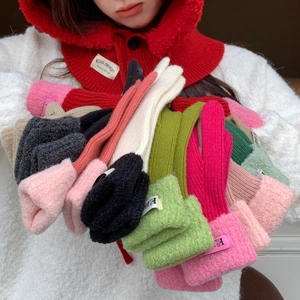 Detail view of colorful winter knitted gloves featuring plush fur cuffs and stylish labels