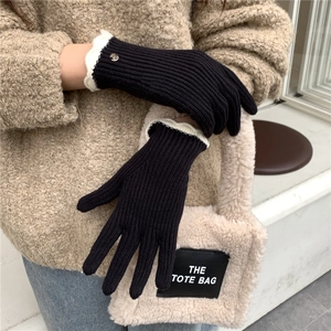 Détail de gants en tricot avec bordure en dentelle blanche et bouton doré élégant