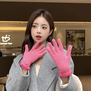 Détail de gants en tricot rose vif avec bords festonnés et petit accent de coeur