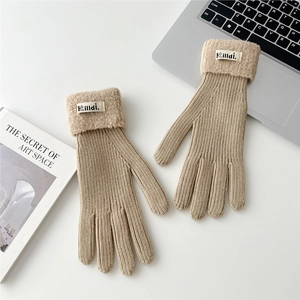 Close-up of camel ribbed knit gloves with white fleece cuffs and branded fabric label