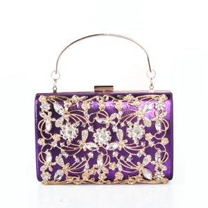 Close-up of purple satin clutch featuring gold hollow floral patterns and sparkling rhinestones