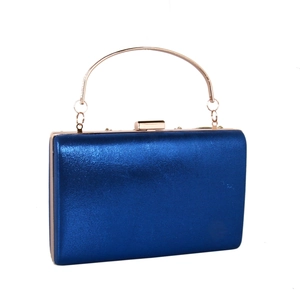 Detailed view of luxury navy blue clutch bag with gold handle and sparkling finish