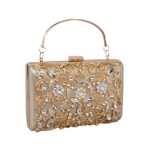 Detailed view of hollow metal floral patterns and sparkling rhinestones on an evening clutch