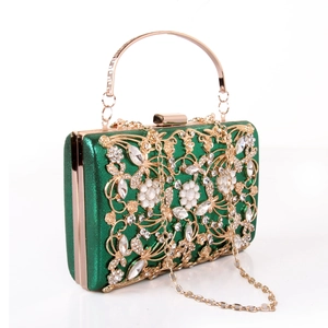 Macro detail of luxury green evening bag with gold floral hollow lace and pearl studs