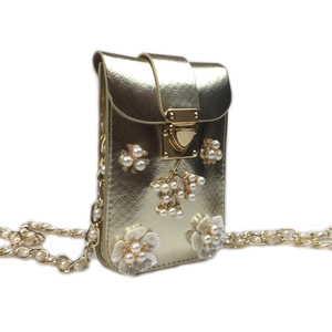Detail of gold floral phone bag featuring pearl diamond accents and luxury chain strap
