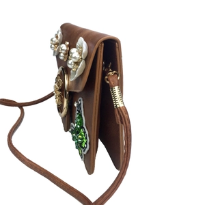 Vue détaillée du sac en cuir marron avec fleurs de perles et papillon pailleté