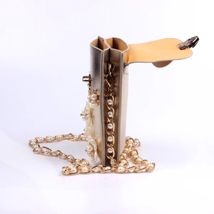 Detail of champagne gold floral phone bag with pearl accents and woven metal chain