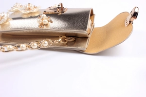 Detail of champagne gold floral cell phone bag with pearl chain and flip cover