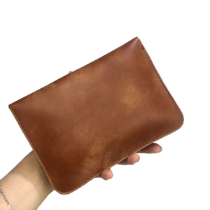 Vue détaillée de la texture du cuir marron et des coutures sur le petit sac bandoulière