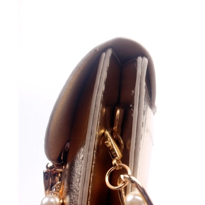 Detail of champagne gold evening bag with metallic finish and decorative pearl chain strap