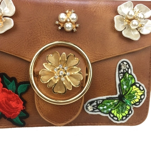 Détails de broderie de rose et papillon avec perles sur le sac à bandoulière marron