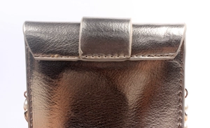 Detail of champagne gold textured leather crossbody bag with pearl embellishment