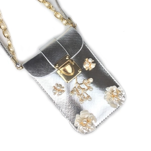 Detail of silver phone bag with pearl flowers, golden hardware, and luxury chain strap
