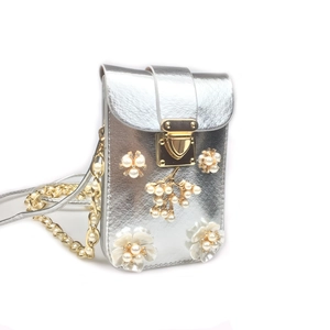 Detail view of the pearl flower decor and silver textured leather on the crossbody phone bag