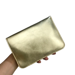 Détail du sac à main en cuir doré avec texture grainée et finitions métallisées