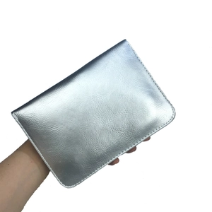 Gros plan d'un sac bandoulière en cuir argenté avec broderie papillon et perles