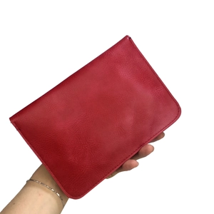 Détail du portefeuille en cuir grainé rouge montrant les coutures et la texture