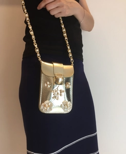 Close-up of golden faux leather crossbody phone bag with 3D pearl flower details
