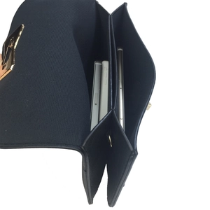 Detail of crossbody bag interior with dual compartments holding two mobile phones