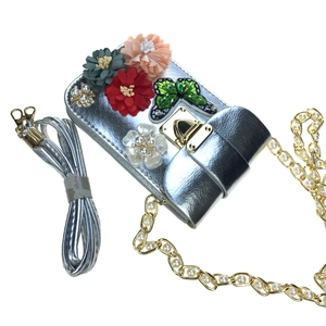 Close-up of silver mini bag with 3D satin flowers, sequin butterfly and pearl chain